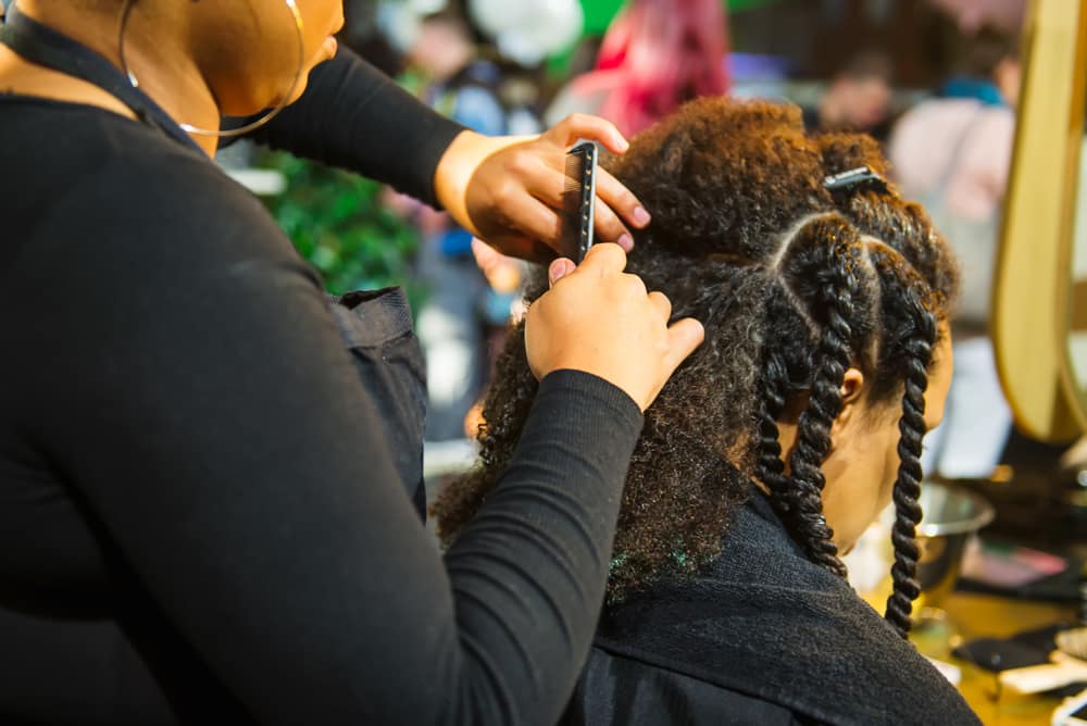 Afro hairdresser styling a client's natural hair